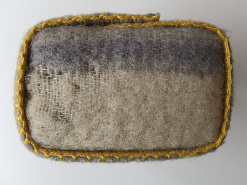 Grijs met geel karakter van wollen deken uit ‘Geborgen herinneringen’ (Salvaged memories) van Jeanne de Bie, textielkunst over verleden