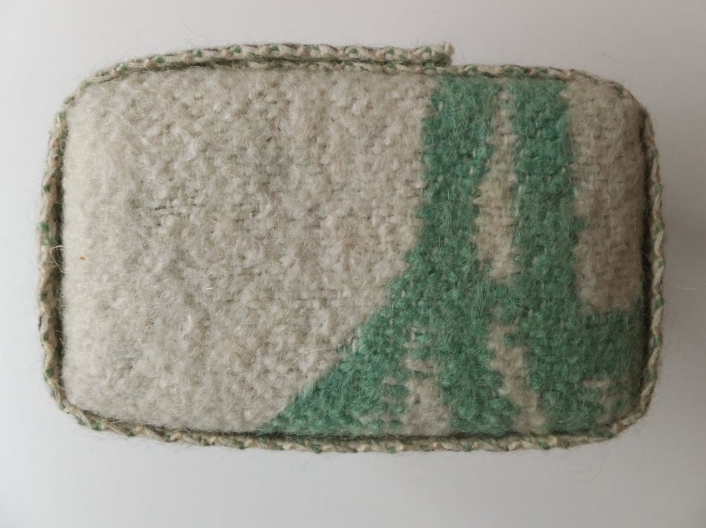 Groen met wit rechthoekig karakter van wollen deken uit ‘Geborgen herinneringen’ (Salvaged memories) van Jeanne de Bie textielkunst over verleden