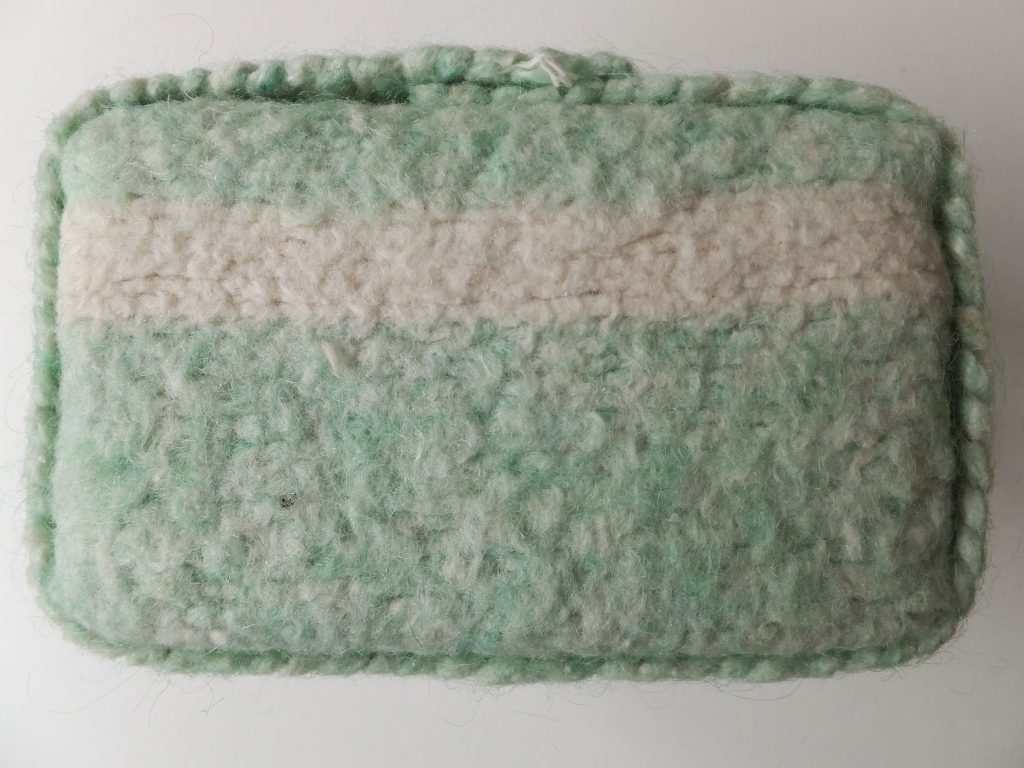  Karakter van wollen deken uit ‘Geborgen herinneringen’ van Jeanne de Bie met de kleuren lichtgroen en wit / beige met lichte achtergrond textielkunst. 